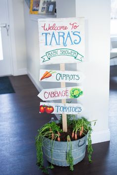 a potted plant sitting on top of a wooden table next to a sign that says welcome to tara's