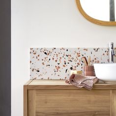 a bathroom with a sink, mirror and wooden cabinet in the corner next to it