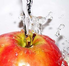 an apple with water splashing out of it