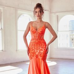 a woman in an orange dress posing for the camera