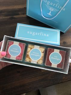 someone is holding three boxes of sugarfina