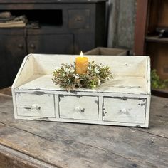 a candle sits on top of an old drawer