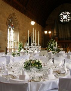 the tables are set with white linens and place settings