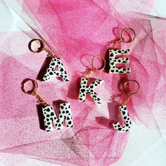 the letters made out of dalmatian tiles are on a pink background with black and white polka dots