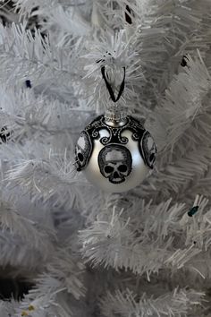 a white christmas tree with a skull ornament on it