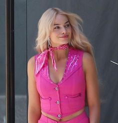 a woman in a pink outfit posing for the camera