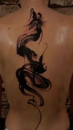 the back of a woman's body with a dragon tattoo on her left side