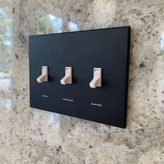 a black and white wall mounted light switch with three lights on it's sides