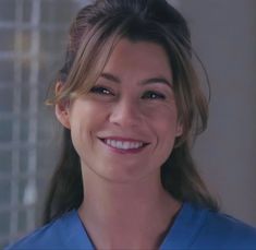 a woman in scrubs smiling at the camera