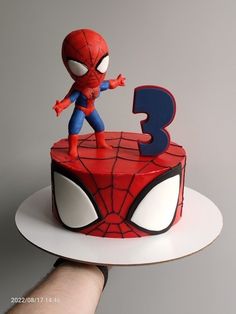 a spiderman birthday cake with the number 3 on it's side and hands