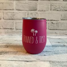 a red wine tumbler sitting on top of a wooden table