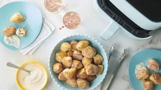 two bowls filled with doughnuts next to a toaster and other food items