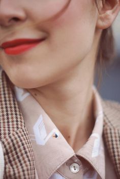 a close up of a person wearing a shirt and tie with an orange lipstick color