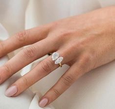 a close up of a person's hand with a diamond ring on their finger