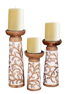 three candles sitting on top of each other in front of a white background with an intricate design