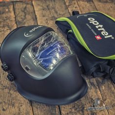 a helmet and bag sitting on top of a wooden floor next to it's contents