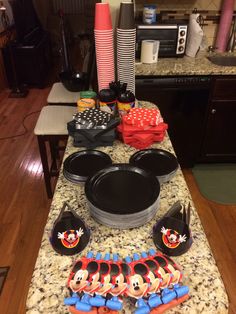 mickey mouse party supplies on a kitchen countertop with minnie mouse plates and napkins