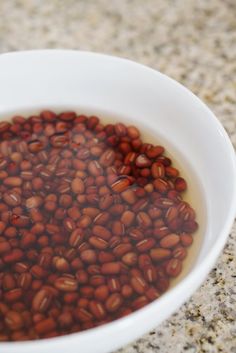 a white bowl filled with red beans on top of a counter