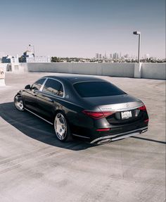 the rear end of a black mercedes s - class sedan parked in an empty parking lot