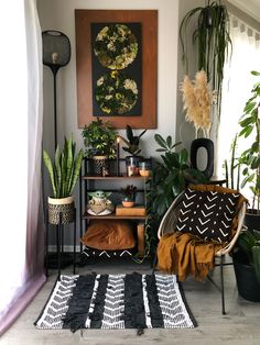 a living room with plants and rugs on the floor, potted plants in front of a painting