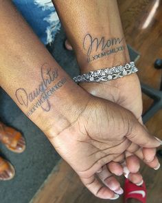 two people holding hands with matching tattoos on their arms that say, mom and daughter