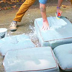 a man sanding down some blue cushions