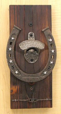 a wooden plaque with a horse shoe and hat on it's face, attached to a wall