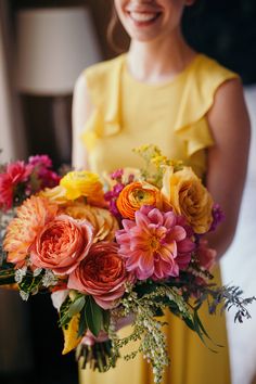 a woman in a yellow dress holding a bouquet of flowers