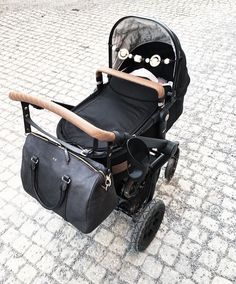 a baby stroller with a black bag on it