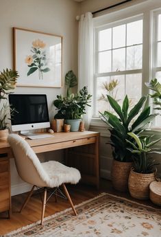 a home office with plants and a computer