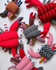 several colorful stuffed animals are arranged on a white surface with red and black striped socks