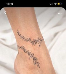 a woman's foot with flowers and leaves on the top of her leg,