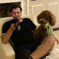 a man sitting on a couch with a stuffed dog