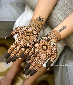 two hands with henna tattoos on them