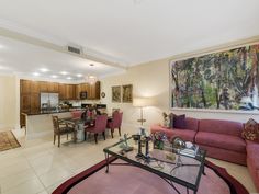 a living room filled with furniture and a painting hanging on the wall above it's fireplace