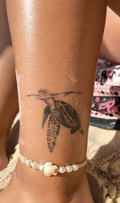 a woman's foot with a tattoo on the side of her leg and a turtle on it