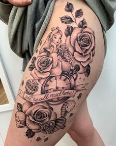 a woman's thigh with tattoos and roses on it