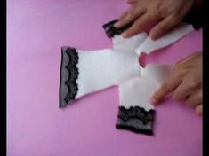 someone is making something out of white paper and black lace on the top of it