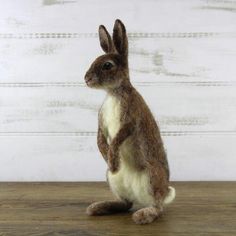 a stuffed rabbit sitting on top of a wooden table