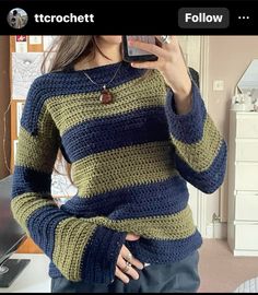 a woman is taking a selfie with her cell phone while wearing a striped sweater