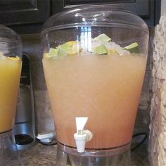 two blenders filled with orange juice on top of a kitchen counter next to each other