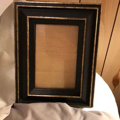 a black and gold frame sitting on top of a bed