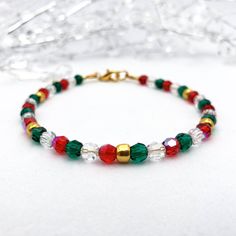 Looking for a festive Christmas beaded bracelet that will add just the right amount of sparkle to your outfit? This tasteful bracelet is the perfect choice!  The premium quality Preciosa 4mm round faceted crystal beads shimmer in shades of red, green, and clear, plus shiny gold glass beads, capturing the essence of the holiday season.  It is a perfect accessory for holiday parties, family gatherings, or as a thoughtful gift. Let this bracelet add a touch of festive magic to your ensemble! 🎄✨ Explore our collection of Christmas bracelets at https://etsy.me/48kWWWs. This bracelet is designed for style and comfort as it features a gold-plated clasp with wire guards on each end to protect the wire from wearing down over time and to prevent scratches or snags on your skin and clothing. The str Christmas Gift Jewelry With Faceted Beads, Red Christmas Bracelets For The Holidays, Red Christmas Bracelets For Holiday, Red Christmas Bracelet For Holiday, Holiday Festive Jewelry Bracelet, Red Christmas Festive Bracelets, Red Christmas Holiday Bracelet, Adjustable Festive Bracelets With Faceted Beads, Festive Bracelets With Faceted Beads