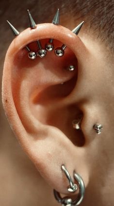 an ear with spikes attached to it's side and two piercings on the end