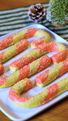 there are some candy shaped like carrots on a white plate with pine cones in the background