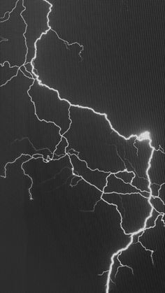 a black and white photo of lightning in the night sky, taken from an airplane window