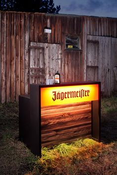 an illuminated sign in front of a wooden building with the word aggermetier on it