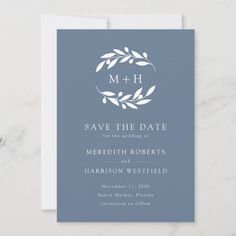 save the date card with an elegant wreath and leaves design on it, in blue