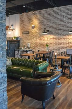 a living room filled with furniture next to a brick wall