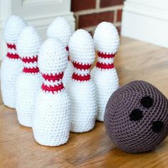 two crocheted bowling pins and a ball on the floor